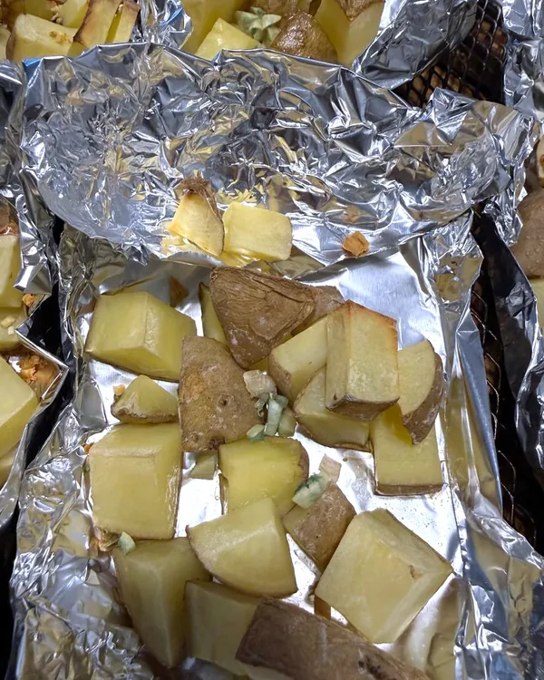 Papas con ajo, horno a 200 °C. Ajo fresco agregado 7 minutos antes de sacar las papas.